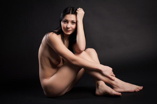Nude sexy brunette on a black background - Foto, Imagen