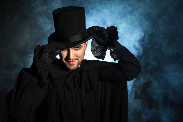 Man in a black top hat and cloak. Demonic image. Magician illusionist - Fotó, kép