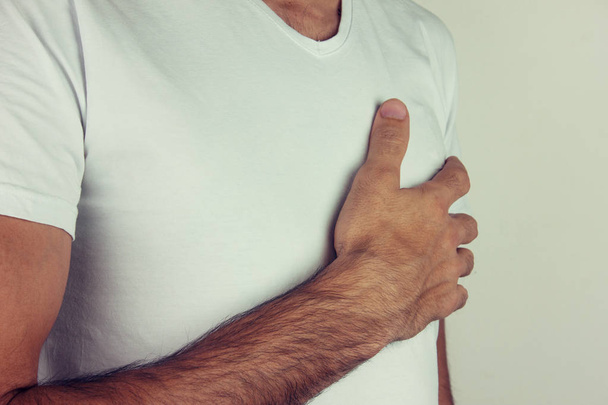 Młodego człowieka, ból w klatce piersiowej lub atak serca na biały backgrou - Zdjęcie, obraz