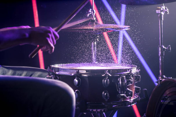 el hombre toca los tambores, en el fondo de luces de colores
 - Foto, Imagen