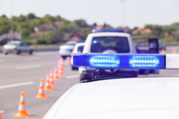 Politie auto noodverlichting tijdens snelweg verkeersgeleiding - Foto, afbeelding