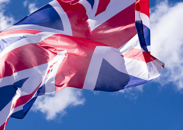 British Flag waving in the Wind against blue Sky - Фото, изображение