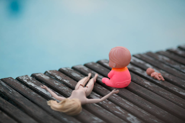 プールのそばの木の板に 3 つの人形のクローズ アップ ビュー - 写真・画像