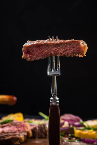 Bistecca di manzo rara media sulla forchetta della griglia
 - Foto, immagini