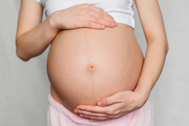 těhotná dívka něžně objala jí břicho - Fotografie, Obrázek