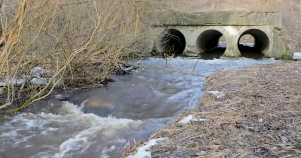 movement of the river in spring through special large pipes on the street - Filmati, video