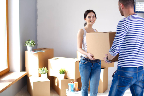 Happy young couple unpacking or packing boxes and moving into a new home. young couple - 写真・画像