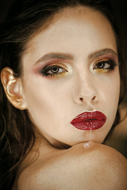 Woman run saliva from mouth with red lips, makeup. Woman with fresh skin face, skincare. Beauty model with glamour look. Fashion girl with bright makeup, beauty. Skincare, cosmetics and visage - Foto, afbeelding