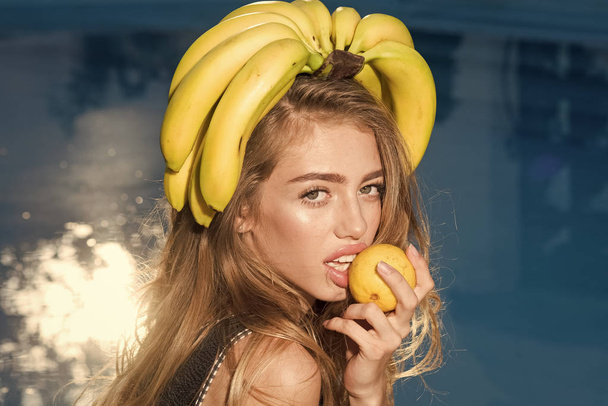 Nainen rentoutuu uima-altaassa sitruunan kanssa. Vitamiini banaani tyttö lähellä vettä. Ruokavalio ja terveellinen luomuruoka, kasvissyöjä. Seksikäs nainen trooppisia hedelmiä altaassa. Kesäloma ja matka mereen
 - Valokuva, kuva
