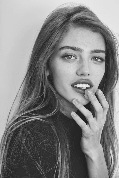 Pretty smiling girl putting gel or balm on sexy lips - Valokuva, kuva