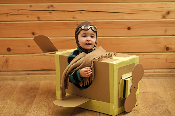 Little dreamer boy playing with a cardboard airplane - Fotoğraf, Görsel