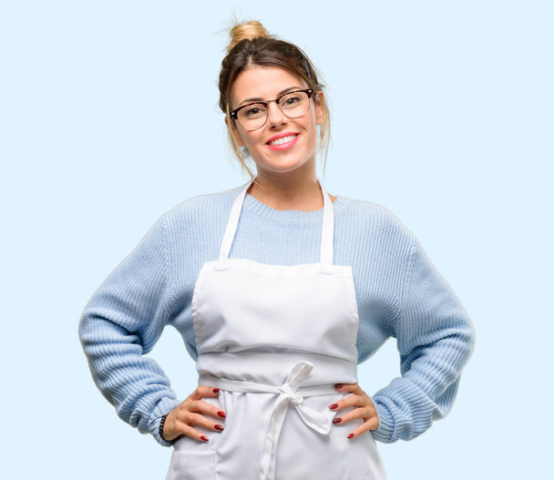 Young woman shop owner, wearing apron confident and happy with a big natural smile laughing - Photo, Image