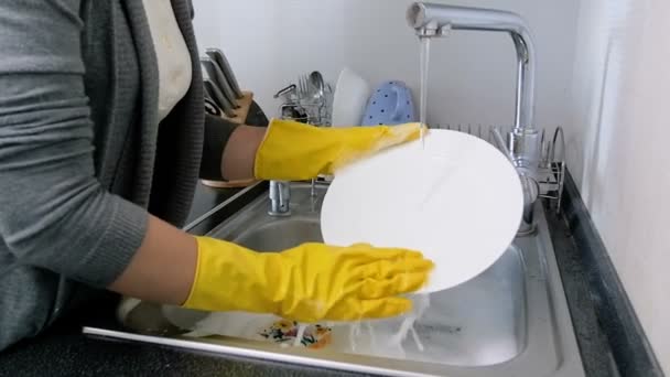 Closeup αργή κίνηση μήκος σε πόδηα του νεαρή γυναίκα το πλύσιμο των πιάτων στο νεροχύτη της κουζίνας - Πλάνα, βίντεο