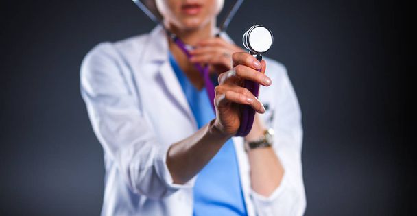 Kobieta-lekarz ze stetoskopem słuchającym, odizolowana na szarym tle - Zdjęcie, obraz