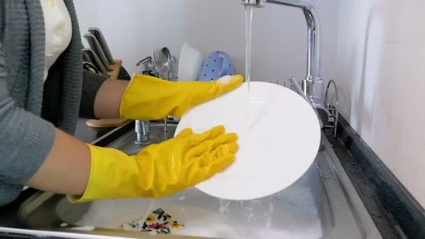 キッチンでお皿を洗う黄色いラテックス手袋で若い女性のクローズ アップのスロー モーション ビデオ - 映像、動画