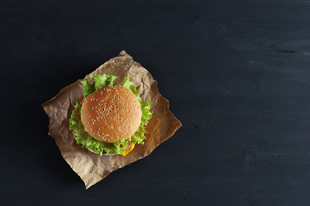 Burger with a bun with sesame seeds, herbs - Foto, afbeelding