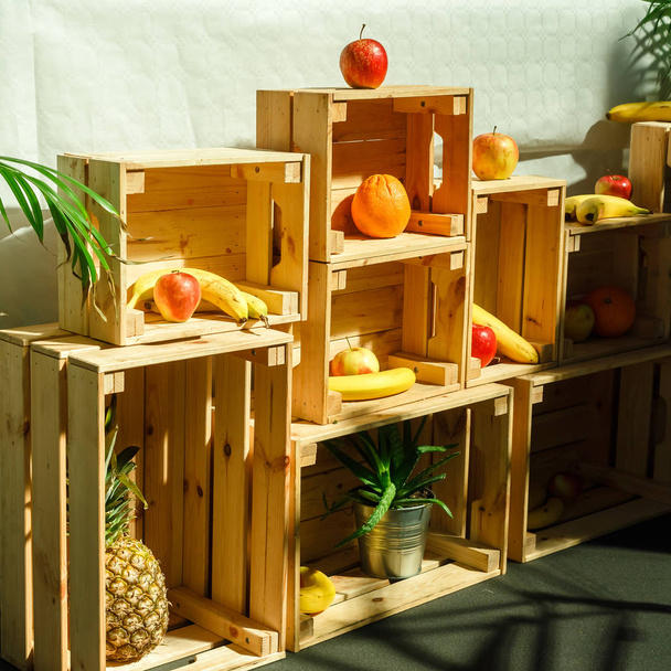 Bananen, Orangen, Äpfel in Holzkisten. Verkauf von frischem Obst in - Foto, Bild