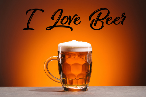primer plano vista de taza de cerveza fría y me encanta letras de cerveza sobre fondo naranja
 - Foto, Imagen