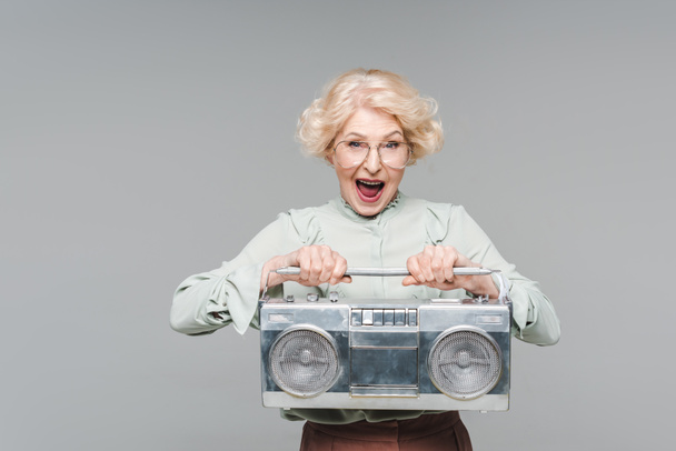 shouting senior woman with boombox isolated on grey - Foto, imagen