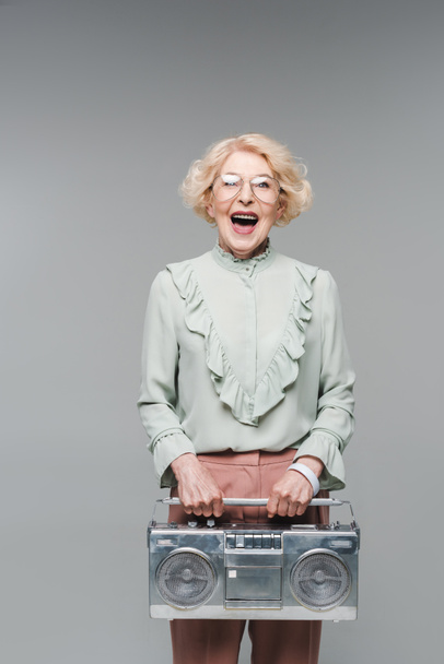 schreiende Seniorin mit Vintage-Boombox isoliert auf grau - Foto, Bild