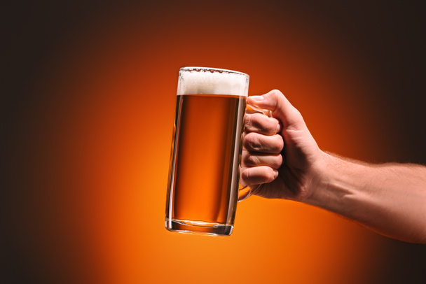 recortado disparo de hombre sosteniendo taza de cerveza fría sobre fondo naranja
 - Foto, Imagen