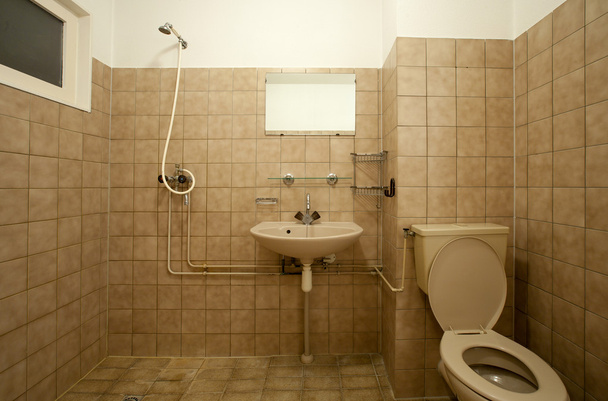 Old empty bathroom with brown tiles - Фото, изображение