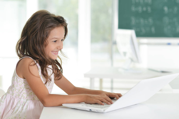 Sevimli küçük kız evde laptop ile ödev - Fotoğraf, Görsel