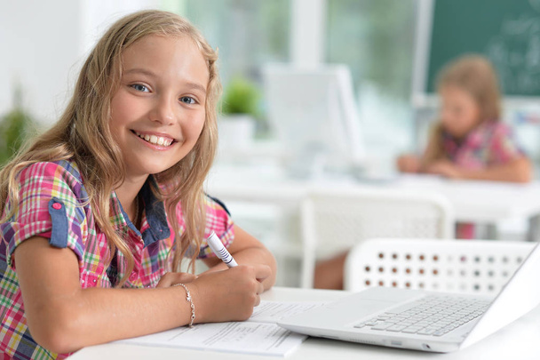 Cute little girl doing homework with laptop at home - Φωτογραφία, εικόνα