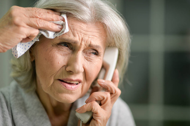 Portrait of upset senior woman calling doctor  - Fotó, kép