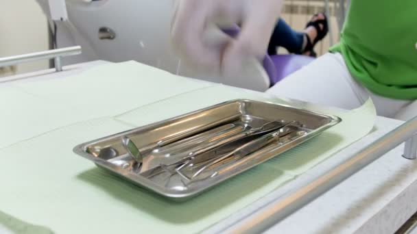 Closeup 4k footage of dentist takes special instrument for table while inspecting patients teeth - Video