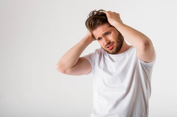 portrait of young bearded man in white shirt have headache on grey background - Foto, Imagem