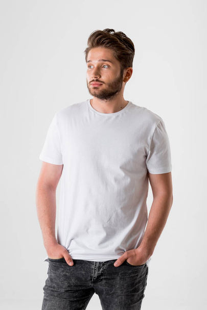 portrait of young bearded man in white shirt on grey background  - Foto, Bild