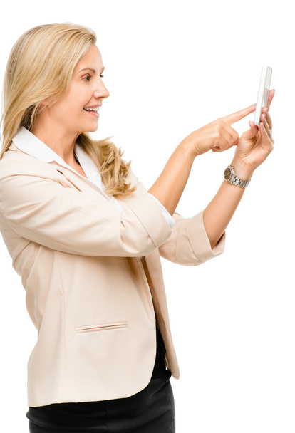 Mulher madura usando smartphone touchscreen isolado na parte traseira branca
 - Foto, Imagem