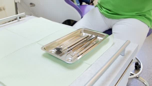 Primer plano 4k video de dentista en guantes de protección toma instrumento estéril de bandeja de metal
 - Metraje, vídeo