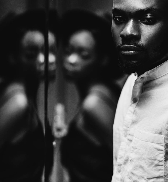 casual pareja afroamericana cerca del espejo, foto en blanco y negro
 - Foto, imagen