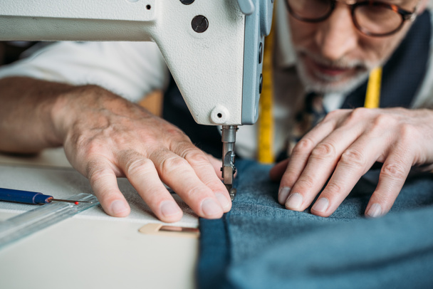 imagen recortada de la costurera tela de coser con máquina de coser en el taller de costura
 - Foto, Imagen