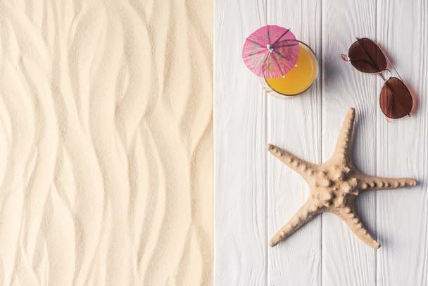 Cocktail avec étoiles de mer et lunettes de soleil sur la plage de sable
 - Photo, image