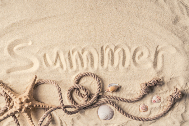 Étoile de mer et coquillages avec corde sur sable clair avec inscription estivale
 - Photo, image