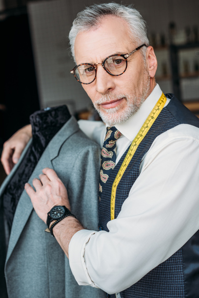 maniquí de abrazo sastre guapo con chaqueta en el taller de costura
 - Foto, imagen