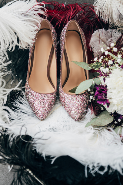 Close-up van bruids schoenen, bruiloft boeket en veren voor rustieke bruiloft - Foto, afbeelding