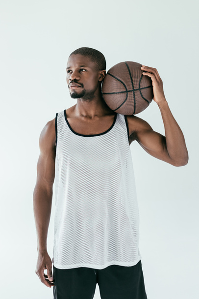 pěkný africký americký basketbalista v oblečení s míčem, izolované na bílém - Fotografie, Obrázek