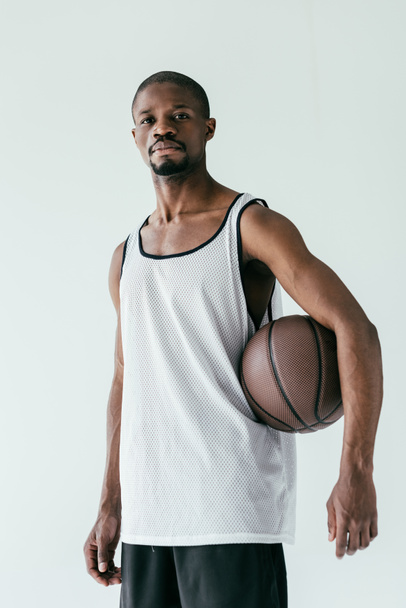 αθλητική Αφρικανικός Αμερικανός μπασκετμπολίστας σε αθλητικά είδη με μπάλα, απομονώνονται σε λευκό - Φωτογραφία, εικόνα
