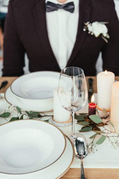 Μερική άποψη του γαμπρού που κάθεται στο τραπέζι σερβίρεται, ρουστίκ γάμος έννοια - Φωτογραφία, εικόνα