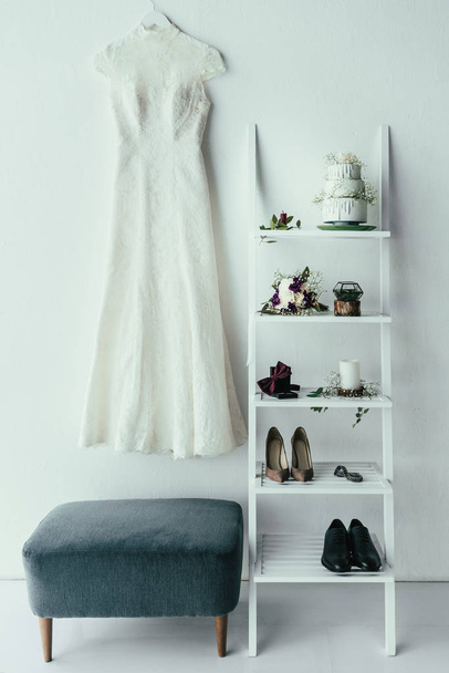 Close-up van Bruidsmode en grooms kleding en accessoires voor rustieke bruiloft in kamer - Foto, afbeelding