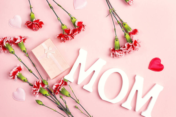 Mother's Day background with carnation flowers and gift box on p - Foto, Bild