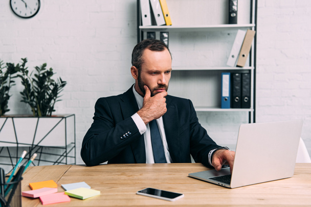 portrait of focused businessman working on laptop at workplace in office - Φωτογραφία, εικόνα