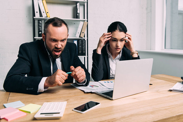 des gens d'affaires stressés et surchargés de travail sur le lieu de travail avec des documents et un ordinateur portable au bureau
 - Photo, image