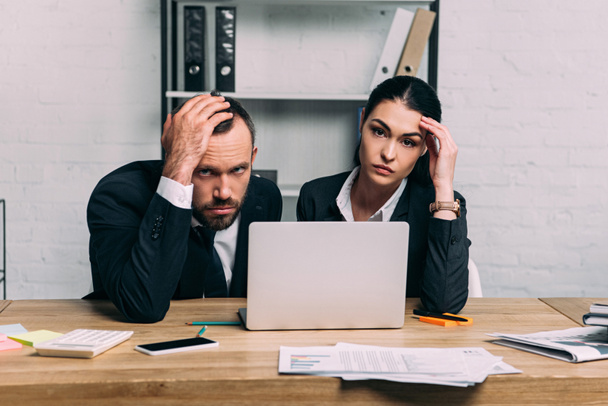 Porträt gestresster Geschäftsleute am Arbeitsplatz mit Dokumenten und Laptop im Büro - Foto, Bild