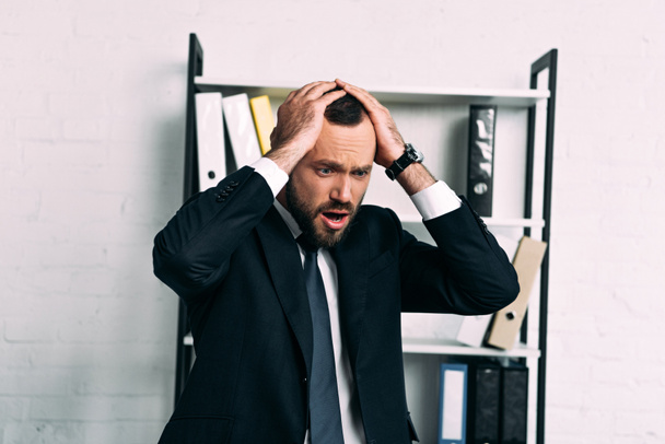 portrait of stressed businessman in suit looking away in office - Foto, Bild