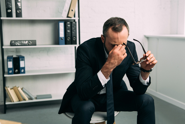 retrato de hombre de negocios con exceso de trabajo en traje con gafas en la oficina
 - Foto, Imagen